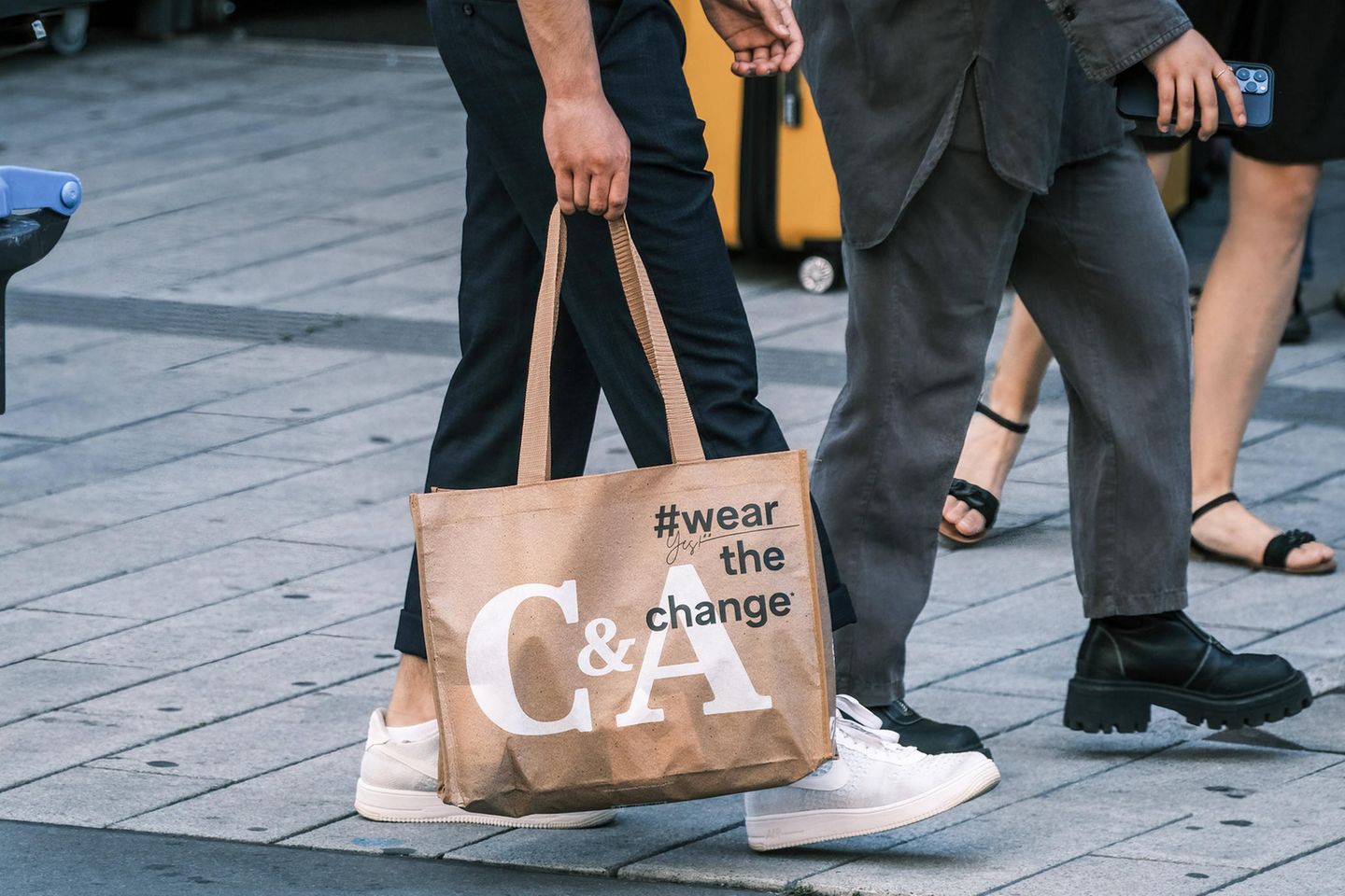 Ein Mann geht mit einer C&A-Tasche auf einer Einkaufsstraße