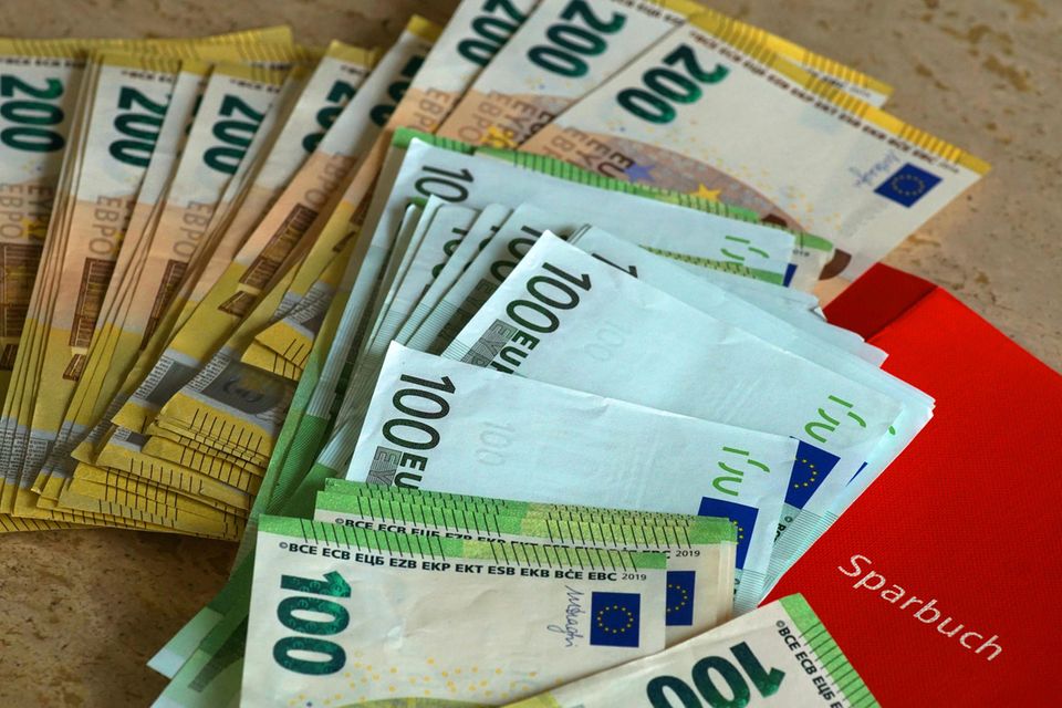 Geldscheine und ein Sparbuch liegen auf dem Tisch