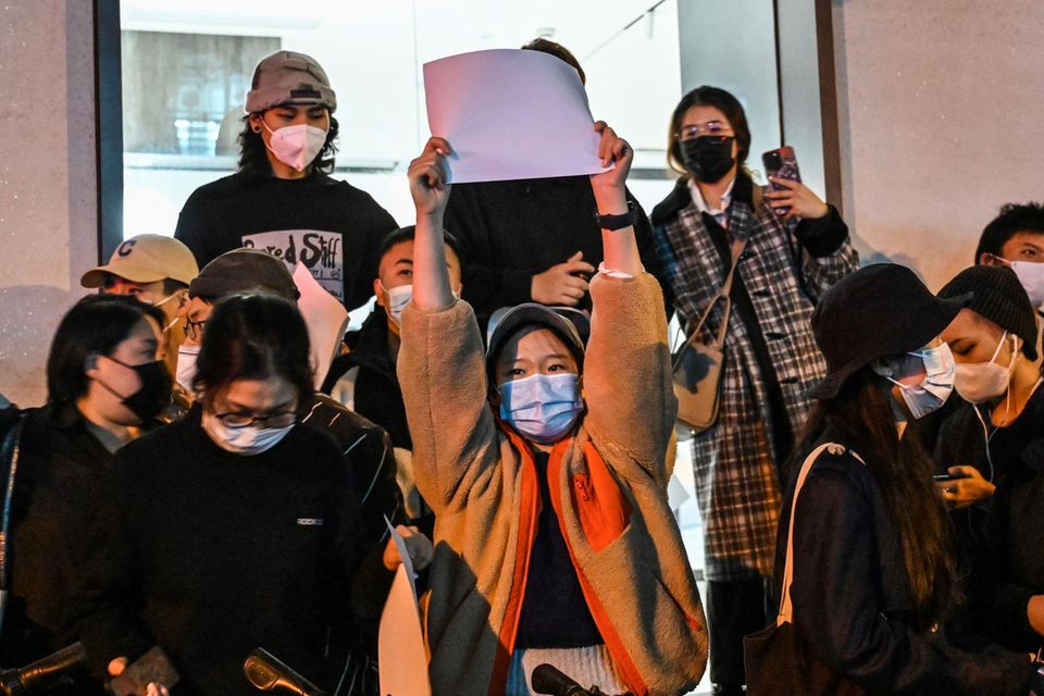 Bei den Protesten in Schanghai hält eine Frau ein weißes unbeschriebenes Blatt hoch
