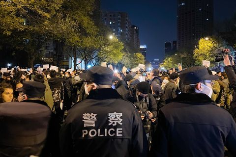 Polizisten stehen in Peking Demonstranten mit leeren weißen Blättern gegenüber