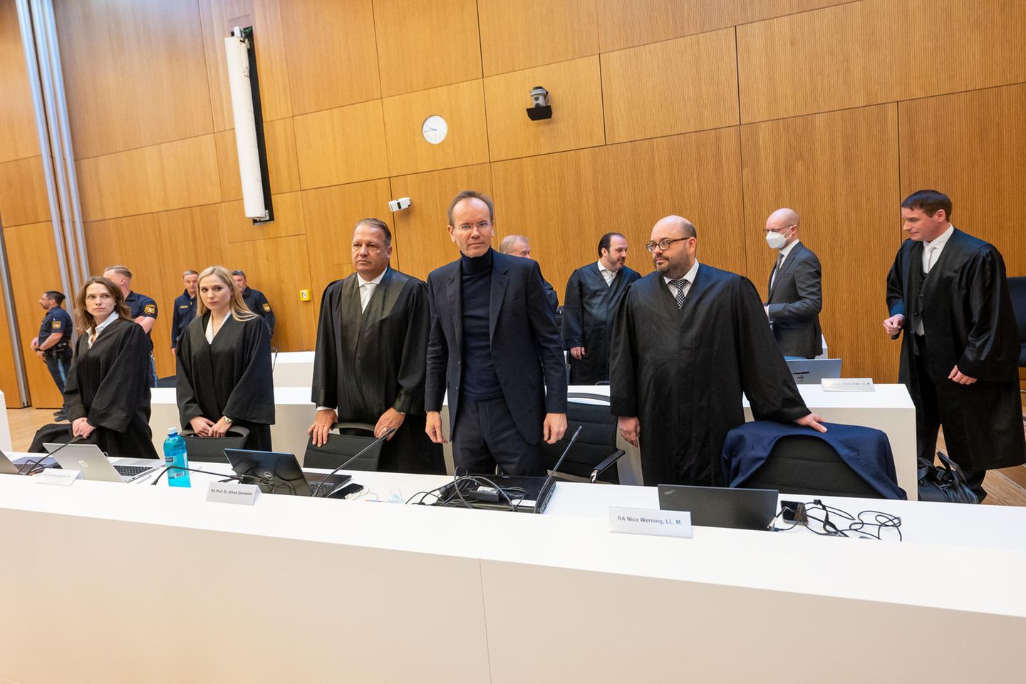 Markus Braun (Mitte) zwischen seinen Anwälten Alfred Dierlamm (links neben Braun) und Nico Werning (rechts neben Braun). Hinter Werning steht der Mitangeklagte Oliver Bellenhaus (Zweiter von rechts, mit Maske)