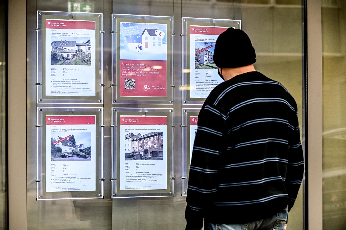 Ein Mann schaut sich Immobilienangebote im Aushang des Immobiliencenters der Sparkasse Essen an