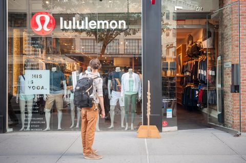 Ein Mann steht vor einem Geschäft der Sportbekleidungskette Lululemon