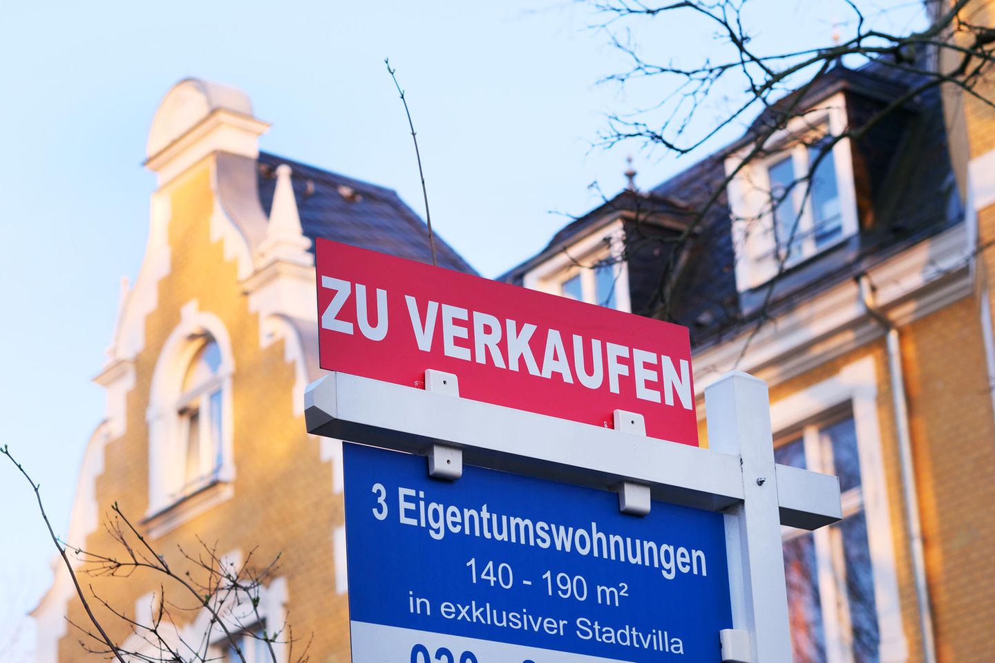 Ein Verkaufsschild hängt vor einem Haus in Berlin