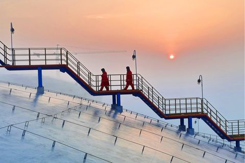Chinesische Arbeiter machen sich an einem LNG Terminal der Sinopec Gruppe an die Arbeit