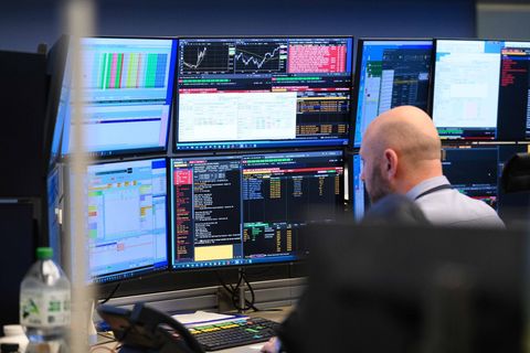 Ein Händler an der Frankfurter sitzt vor diversen Monitoren