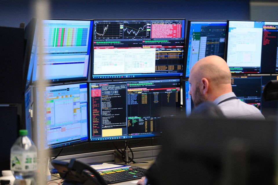 Ein Händler an der Frankfurter sitzt vor diversen Monitoren