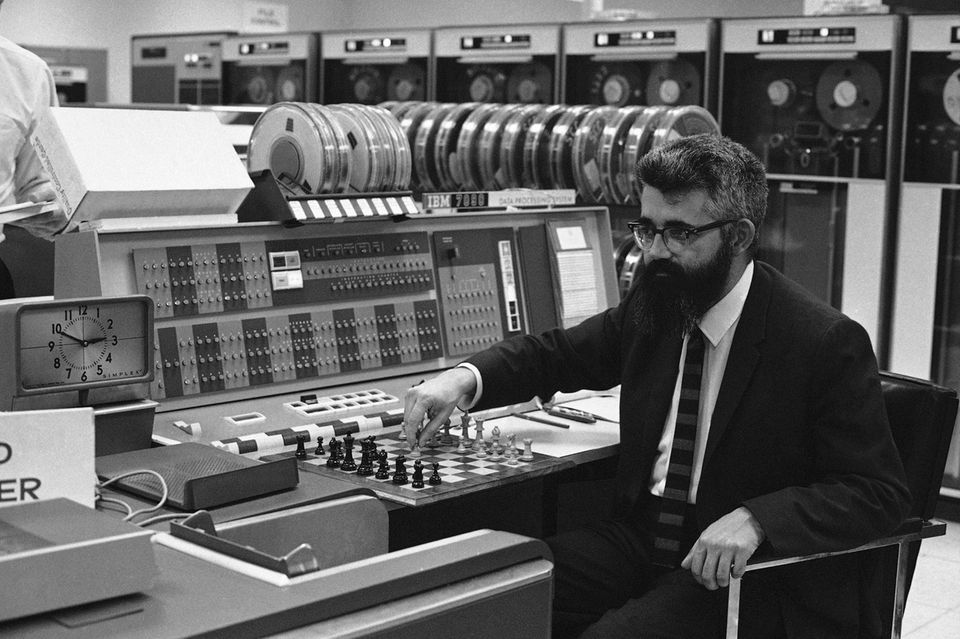 Der Begriff „Artificial Intelligence“ (künstliche Intelligenz) mag naheliegen. Geprägt wurde dieser Begriff aber offiziell im Sommer 1956. Die Konferenz am Dartmouth College im US-Bundesstaat New Hampshire gilt als „Gründungsveranstaltung“ der KI als akademisches Fachgebiet. Deren Organisator, der Programmierer John McCarthy (Foto aus dem Jahr 1966), schlug den Begriff „Künstliche Intelligenz“ vor. Bei dem Treffen wurde auch das erste KI-Programm geschrieben.