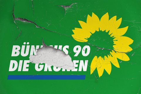 Das Logo der Partei Bündnis 90/Die Grünen auf einer Wand mit abgeplatzter und rissiger Wandfarbe