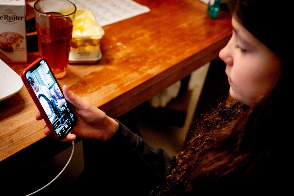 Ein Mädchen schaut sich auf ihrem Smartphone ein Tiktok-Video an