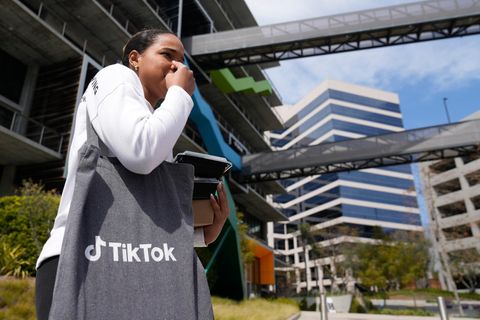 Eine Frau mit einer Tiktok-Tasche steht vor der US-Zentrale des Unternehmens