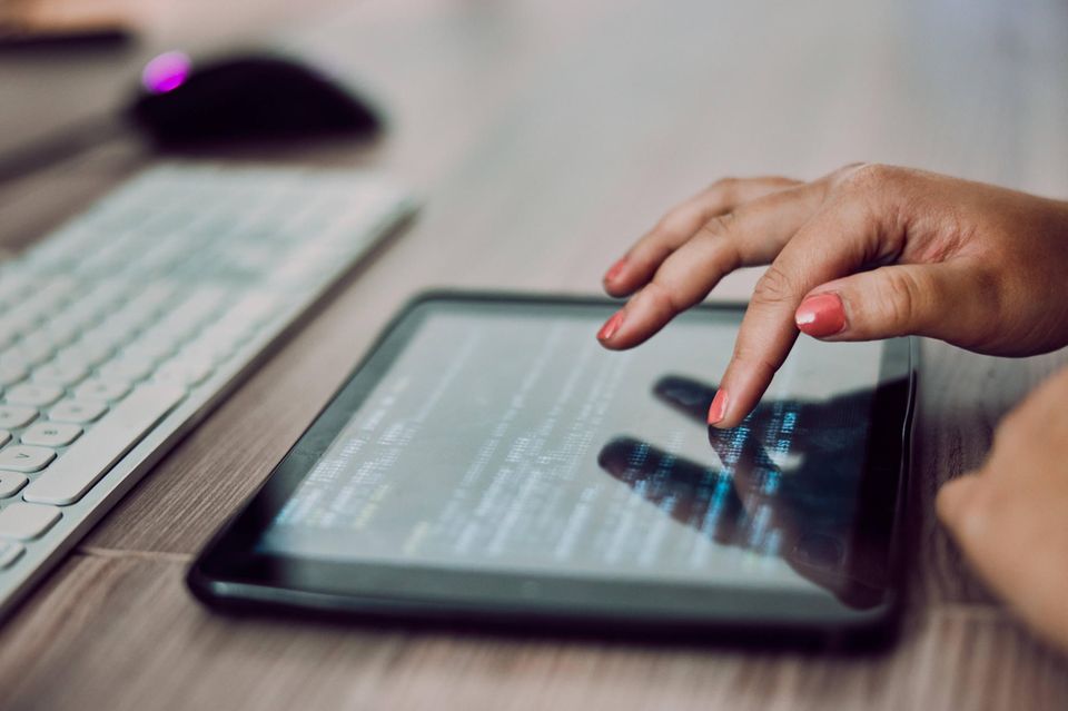 Entwicklerin an einem Tablet: Programme lassen sich normalerweise von überall erstellen