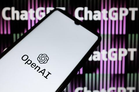 Ein Smartphone vor einem Bildschirm mit ChatGPT-Aufschrift