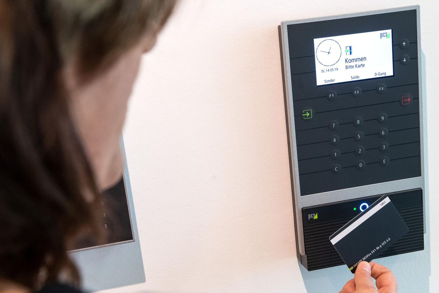 Ein Mitarbeiter erfasst seine Arbeitszeit digital an einem Terminal