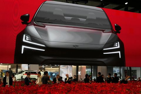 Besucher stehen an einem Blumenbeet auf dem Stand von Polestar bei der Auto Shanghai