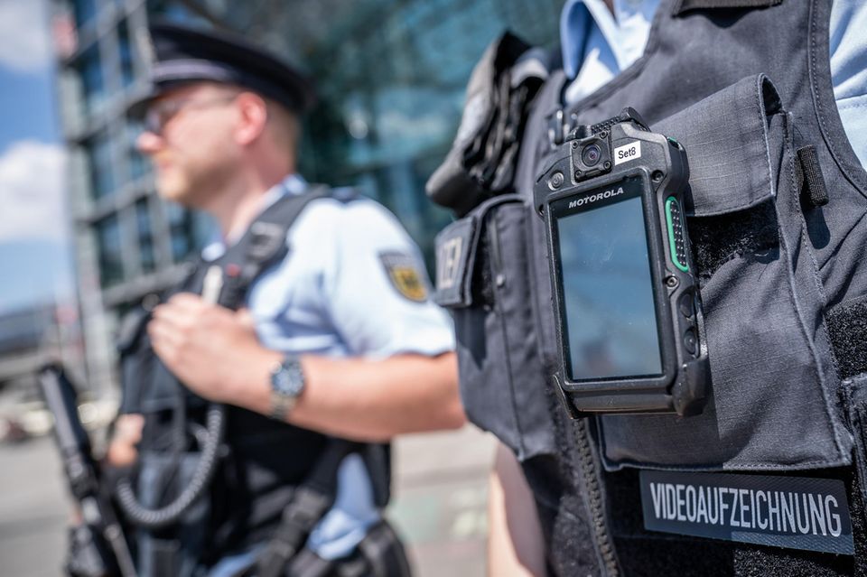 Beamten der Bundespolizeiwache Berliner Hauptbahnhof stehen mit einer Bodycam zur Videoaufzeichnung auf dem Bahnhofsvorplatz