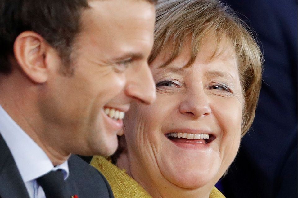 Frankreichs Präsident Macron und Angela Merkel lachen