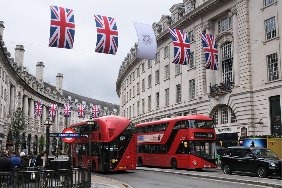 Busse fahren durch die Regent Street, die mit britischen Flaggen geschmückt ist