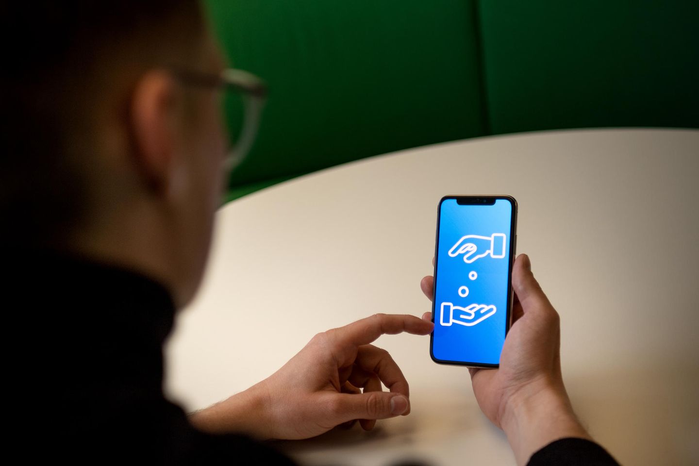 Ein Mann nutzt ein Smartphone zum Geldverkehr