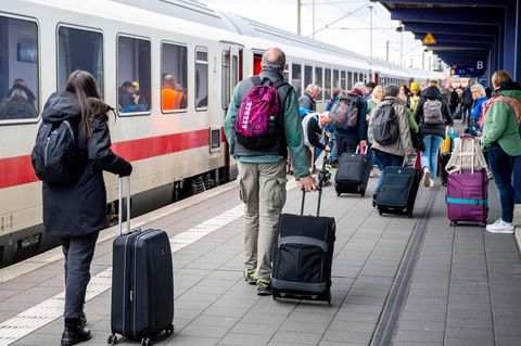 Reisende steigen an einem Bahnhof in einen IC der Deutschen Bahn