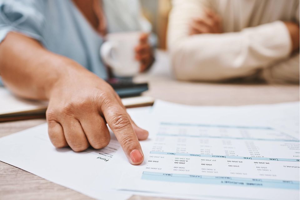 Eine Frau zeigt mit dem Finger auf ein Dokument mit einem Finanzierungsangebot