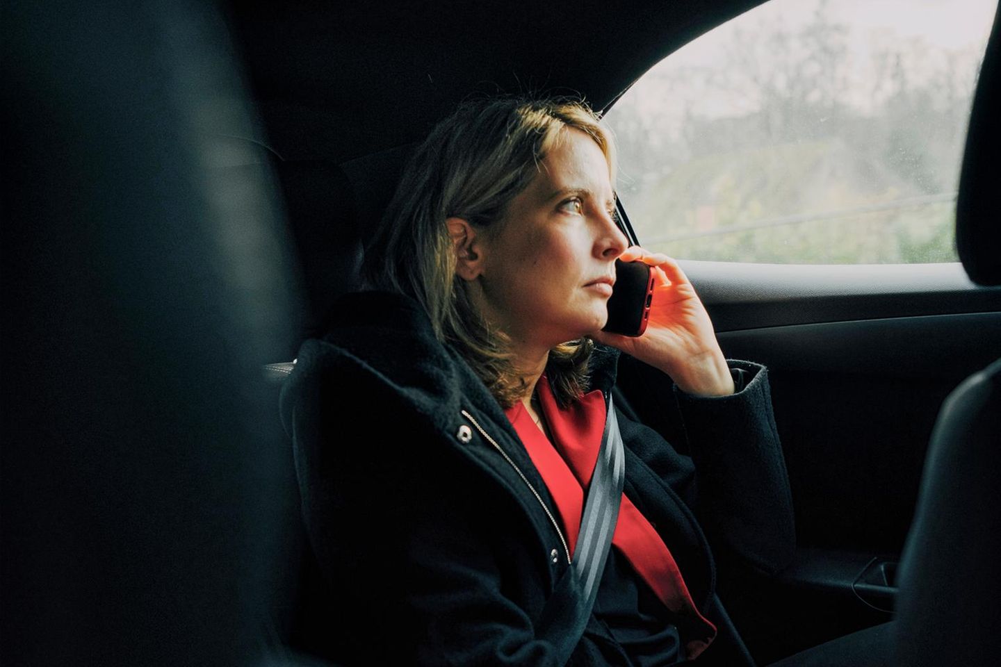 Verena Hubertz sitzt auf dem Rücksitz eines Autos und telefoniert