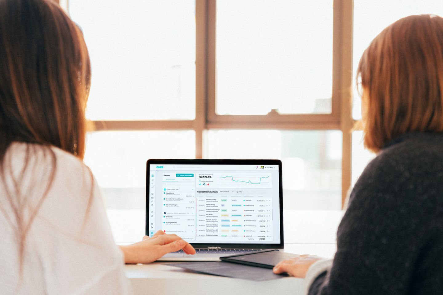 Zwei Frauen sitzen vor einem Computerbildschirm