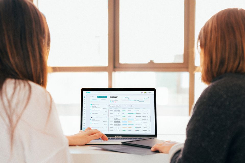 Zwei Frauen sitzen vor einem Computerbildschirm