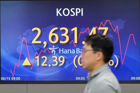 Ein Händler geht an einem Bildschirm vorbei, auf dem der Stand des Kospi-Index zu sehen ist