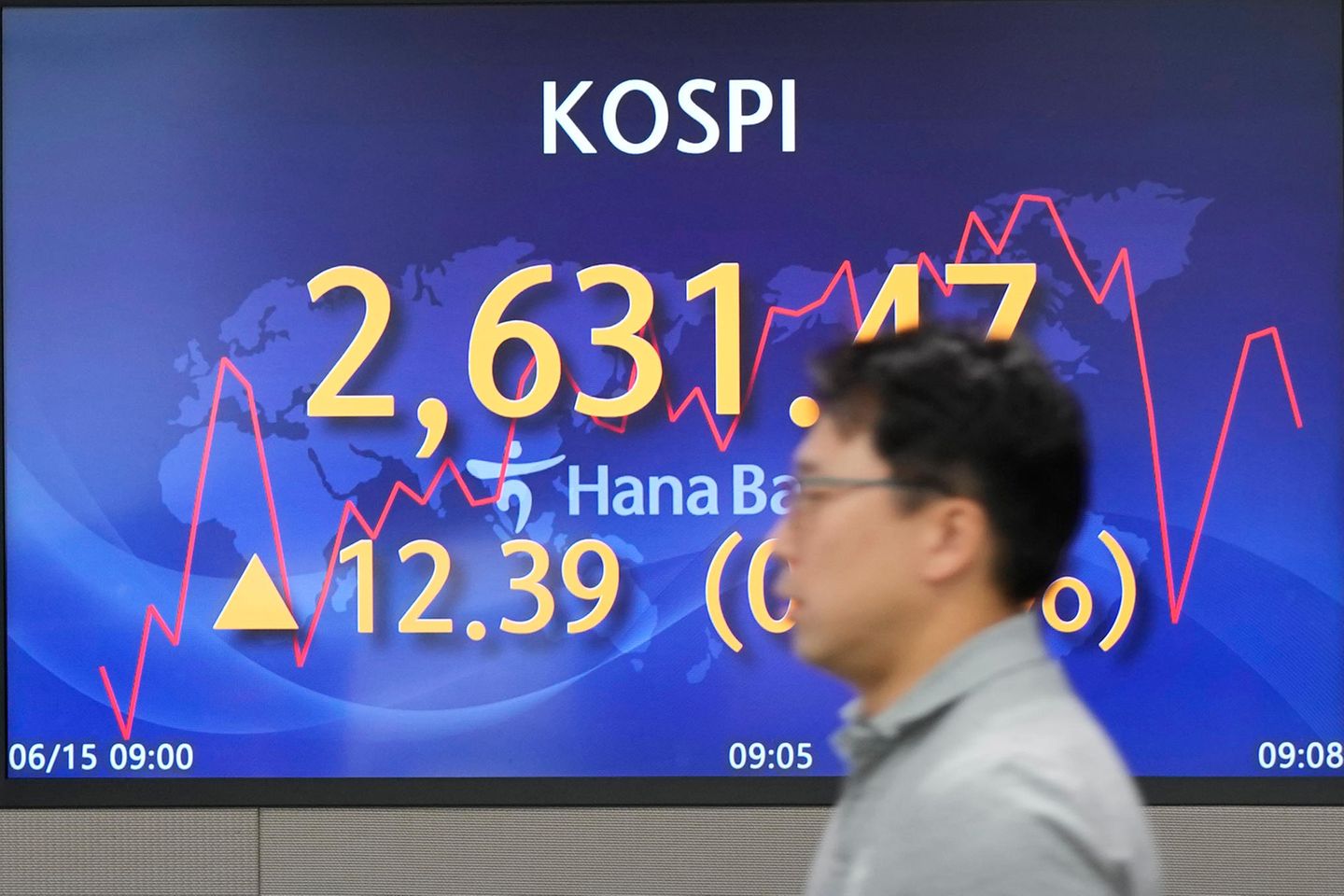 Ein Händler geht an einem Bildschirm vorbei, auf dem der Stand des Kospi-Index zu sehen ist
