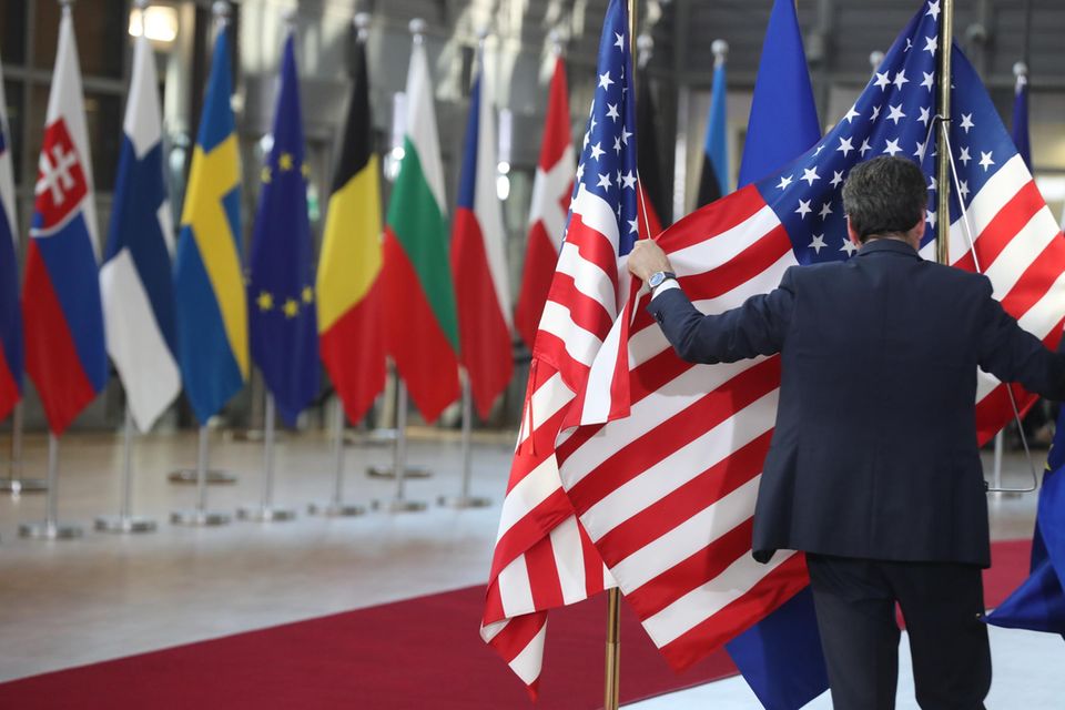 Ein Mann hängt eine US-amerikanische Flagge auf