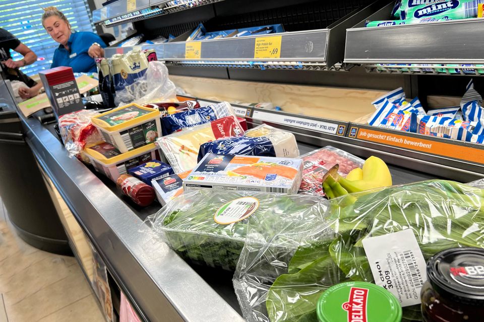 Lebensmittel liegen auf einem Kassenband an einer Supermarktkasse