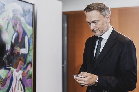 Bundesfinanzminister Christian Lindner schaut in sein Handy