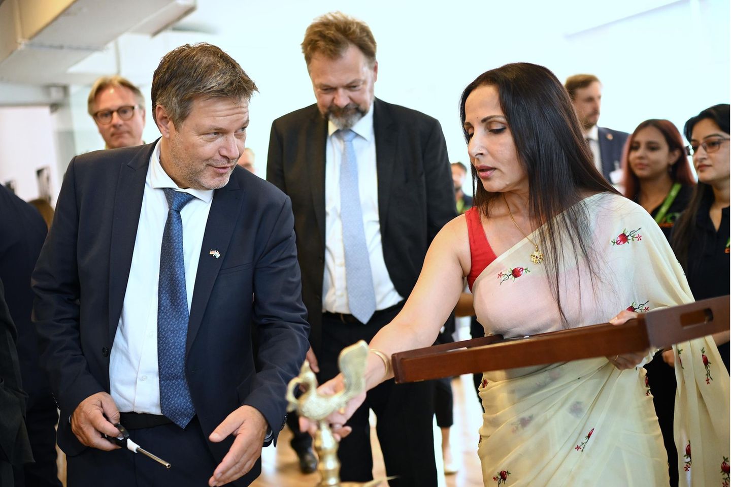 Bei einem Unternehmensbesuch wird Wirtschaftsminister Habeck (l.) mit einer traditionellen Willkommenszeremonie empfangen