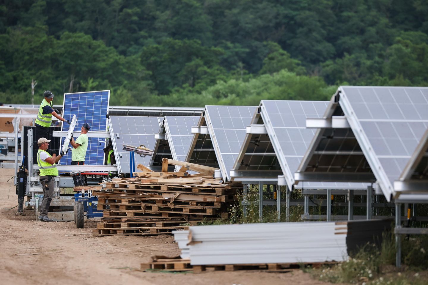 Arbeiter montieren Solarpanele auf dem Gelände des Energieparks Witznitz