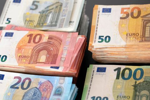 Euro-Banknoten liegen nach Wert gestapelt auf einem Tisch