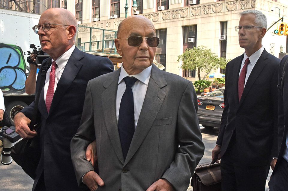 Joe Lewis verlässt das Gerichtsgebäude, er trägt Anzug und Sonnenbrille