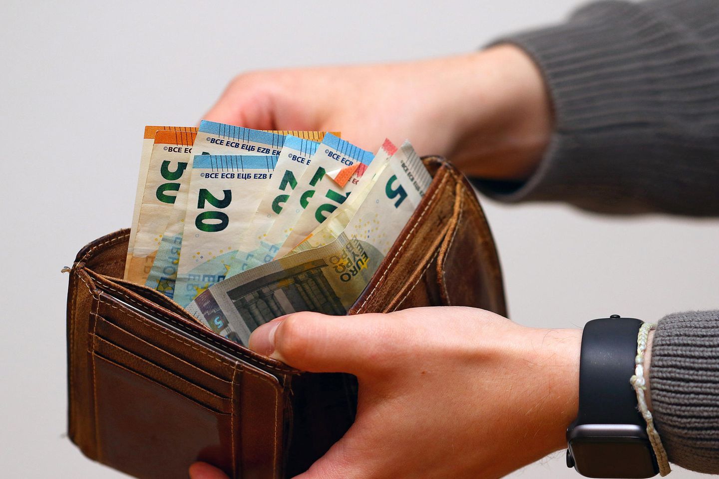 Eine Frau zählt Geldscheine in ihrem Portemonnaie
