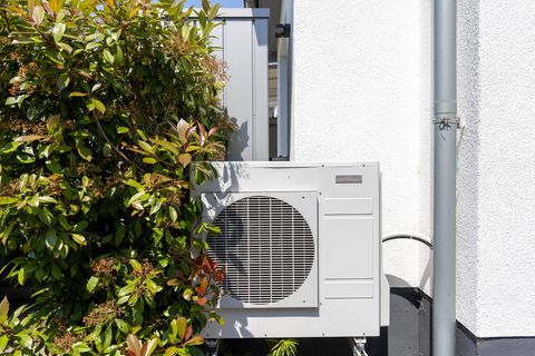 Eine Wärmepumpe steht an einem Haus