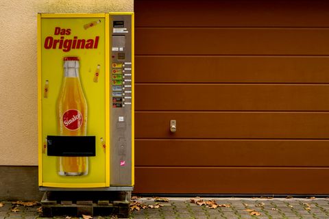Ein Sinalco-Getränkeautomat steht an einer Garageneinfahrt