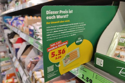 In einer Filiale von Penny hängt ein Preisschild mit der Aufschrift „Wahre Kosten“
