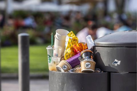 Überfüllter Abfallbehälter mit Plastikmüll