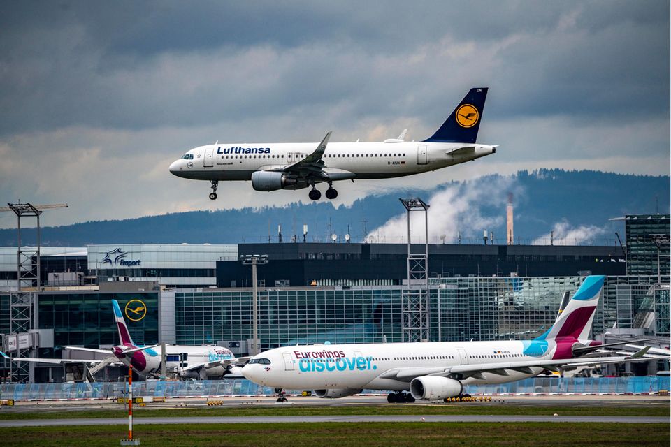 Lufthansa-Flugzeug im Landeanflug, Eurowings-Flugzeug am Boden in Frankfurt am Main