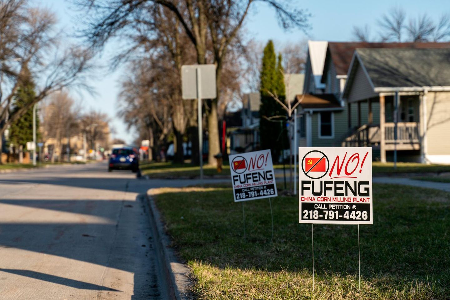 Auf einem Rasenstück an einer Straße stehen Schilder mit der Aufschrift „No Fufeng“