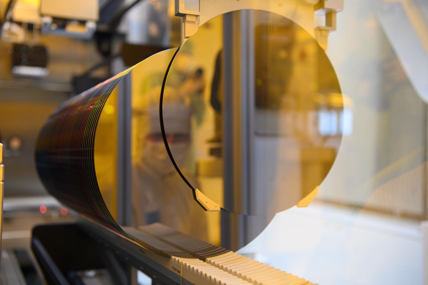 Ein Bosch-Mitarbeiter spiegelt sich in einem 300-Millimeter-Wafer