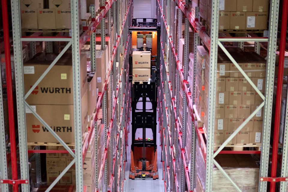 Eine Würth-Mitarbeiterin transportiert in einem Gang eines Hochregallagers eine Palette auf einem Gabelstapler