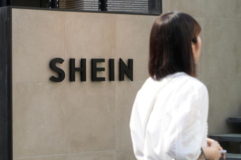 Eine Frau geht an einem Geschäft mit der Aufschrift Shein vorbei