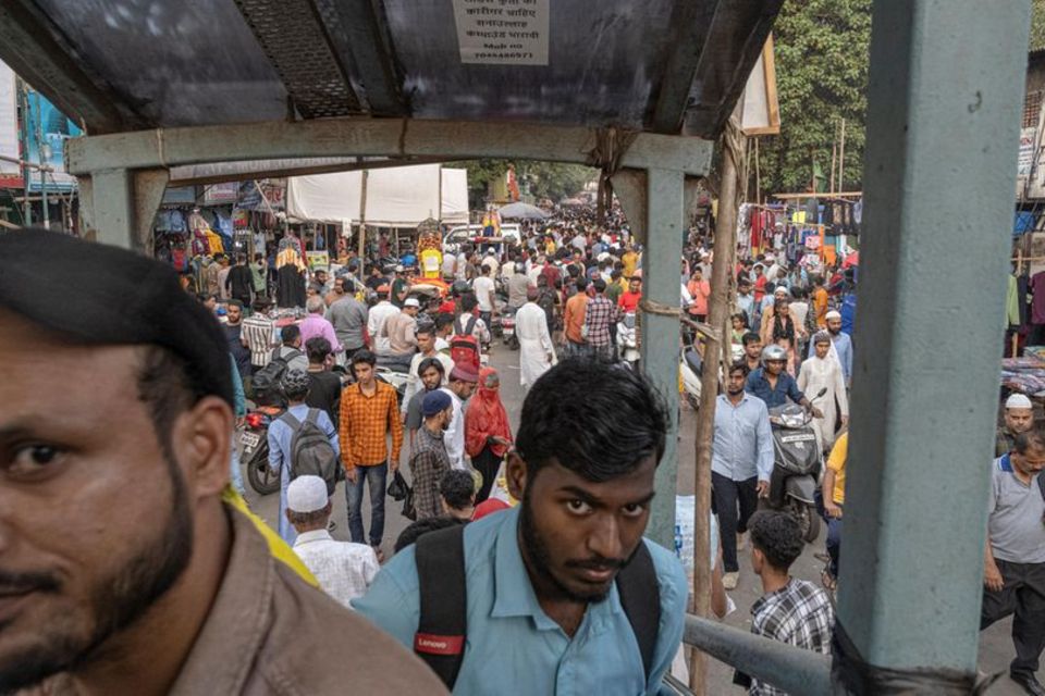 Menschen laufen durch Dharavi in Mumbai, den wohl größten Slum der Welt