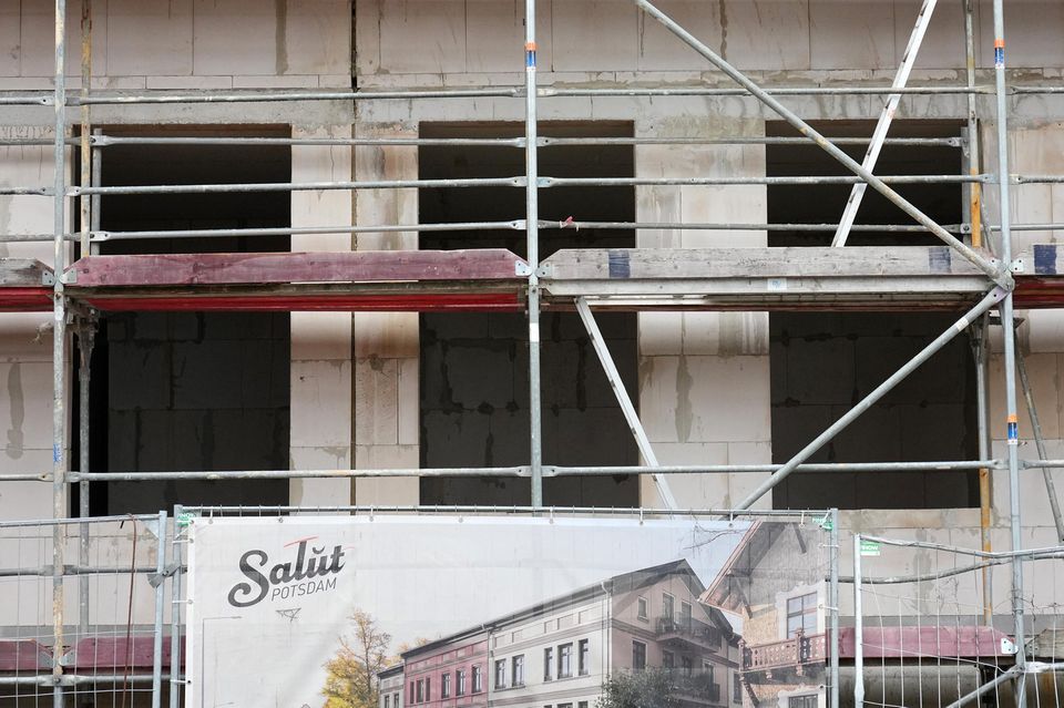 Ein Baugerüst und ein Plakat mit der Aufschrift „Salut Potsdam“ stehen an dem Rohbau
