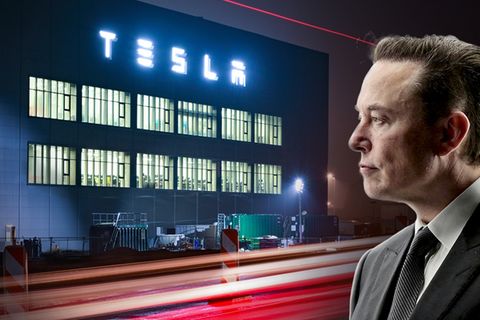 Elon Musk, ein Mann im Profil, vor einer Firma, auf der Tesla steht